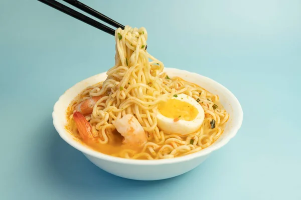 タイ風のスパイシーなスープとエビをトッピングした麺 Tom Yum Goong と呼ばれる白いボウルに箸で タイのママヌードルエビとチリで作られ ホット スパイシーなメニュー — ストック写真