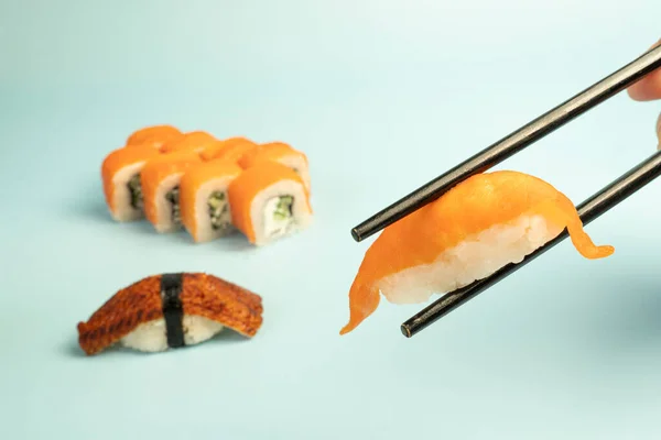Sushi Set Zwarte Eetstokjes Blauwe Achtergrond Japanse Traditionele Keuken Asianfood — Stockfoto