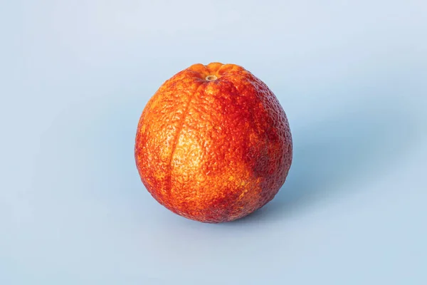 blood red orange citrus fruit on blue background. red orange