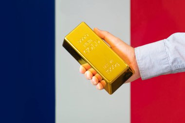 Fransa 'nın altın rezervi. Fransız bayrağı arka planında altın külçesi