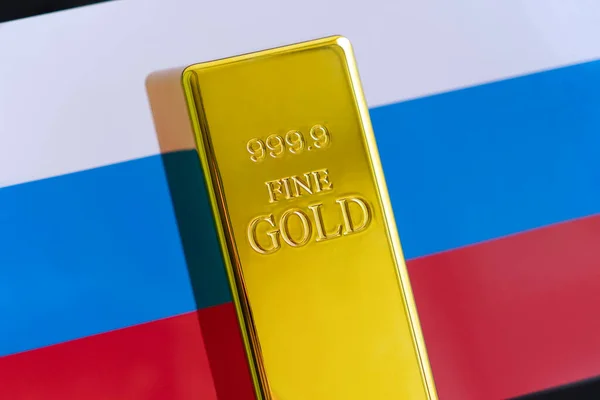 stock image The gold bar is on the national flag of russia. russian Gold Reserve concept