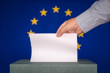 Avrupa Birliği seçimlerinde Avrupa bayrağının arka planına karşı oy kullanan bir adam