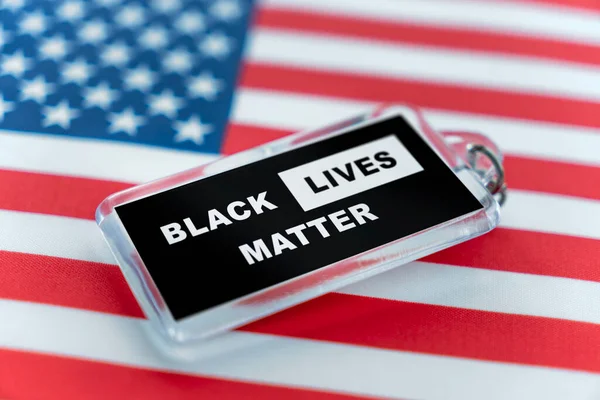 带有Blm运动符号的塑料钥匙链 在美国国旗的背景下 黑人的生命很重要 — 图库照片
