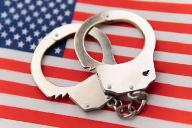 Amerikan bayrağı ve polis kelepçeleri. Ülkede suç ve suç kavramı. Ülkedeki suç kavramı ya da hükümet.