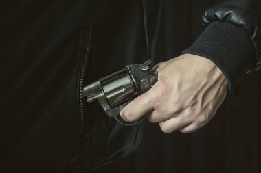 Bir adam cebinden silah çıkarır, nefsi müdafaa ya da baskı konsepti, soygun. Ateşli silahların yasallaştırılması.