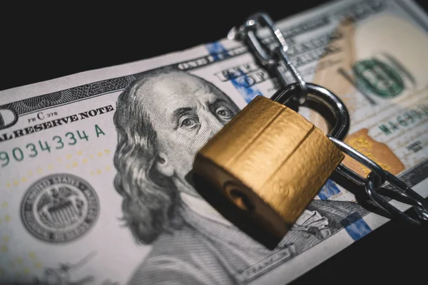 Business safety or financial protection or restriction access. Heap of money in chain with padlock on black. the concept of keeping or banning cash dollars. money is banned.