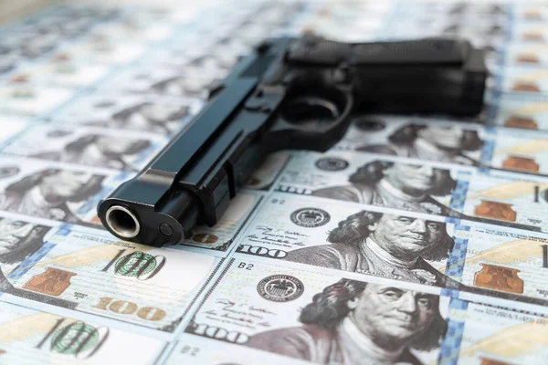 black gun on the background of cash dollars. the concept of criminal money or murder for money. bank robbery,