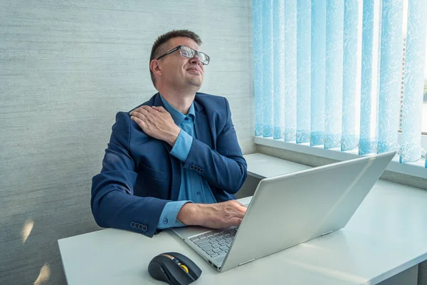 businessman work with computer late at night room. He tired and stressed needs rest. He has shoulder neck and back pain. Working hard and overtime too much going to symptom office syndrome.
