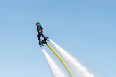 Uçuş tahtası. Uçan kaykayla en uzak uçuş. Gemide uçan bir adam var. Flyboard, kişisel su araçları için bir hava makinesidir. Su altında itiş gücüne izin verir.