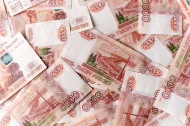 Rus 5000 rublesinin banknotları. Bir deste beş binlik banknot. Rus rublesinin beşte biri parayla kaplı bir platformda dönüyor. Rus 5000 rublesi.