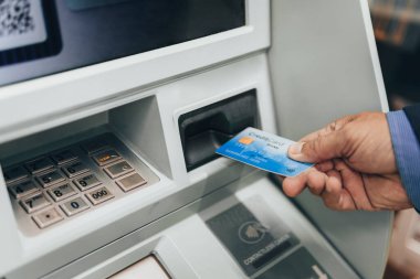 ATM makinesine e-kart sokan bir adamın eli yakın çekim.