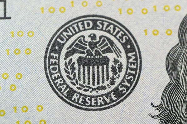 Federal Reserve System logo close-up. US Federal Reserve emblem on hundred dollars banknote as FED consider interest rate hike, economics, inflation control national organization.