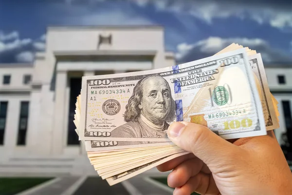 Δολάρια Στο Χέρι Ενός Ανθρώπου Στο Παρασκήνιο Federal Reserve Building — Φωτογραφία Αρχείου