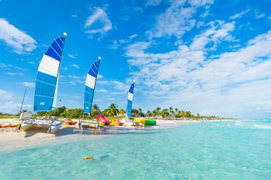 Güneşli bir yaz gününde Küba 'daki Varadero' nun güzel cennet plajı. Temiz turkuaz suyu olan güzel bir deniz manzarası. Yelkenli gemiler kumsalda park halinde..