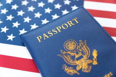Amerika Birleşik Devletleri 'nin yeni mavi pasaportu Amerikan Bayrağı arka planında. Amerikan vatandaşlığı alma kavramı. Birleşik Devletler vatandaşı..