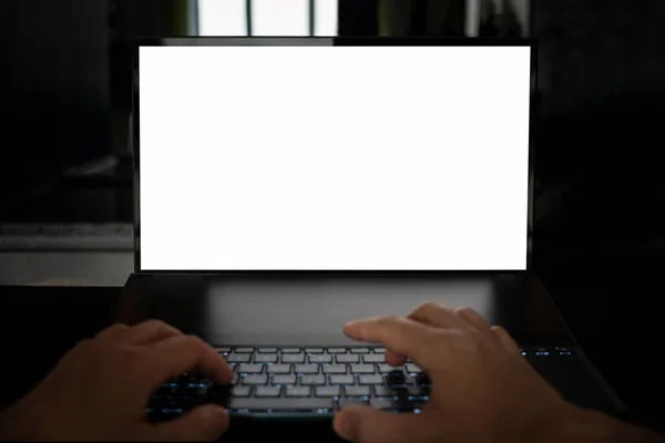 在黑色背景的桌子上使用空白白色屏幕的笔记本电脑来模拟手部图像 程序员的夜间工作 — 图库照片