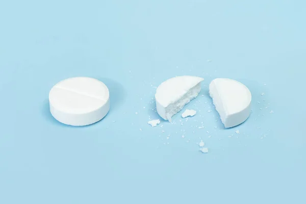 Dvě Pilulky Modrém Pozadí Léky Jedna Tableta Zlomená Polovinu Kulatá — Stock fotografie