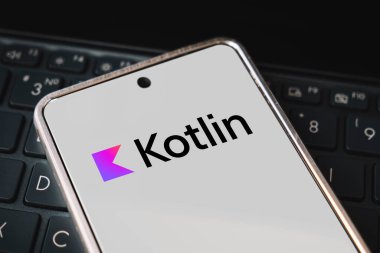 Gezici gelişim için kotlin programlama dili, konsept. Laptop klavyesinde akıllı telefon. Cep telefonu ekranında logo kotlin var. Barnaul. Rusya 28 Mart 2023.