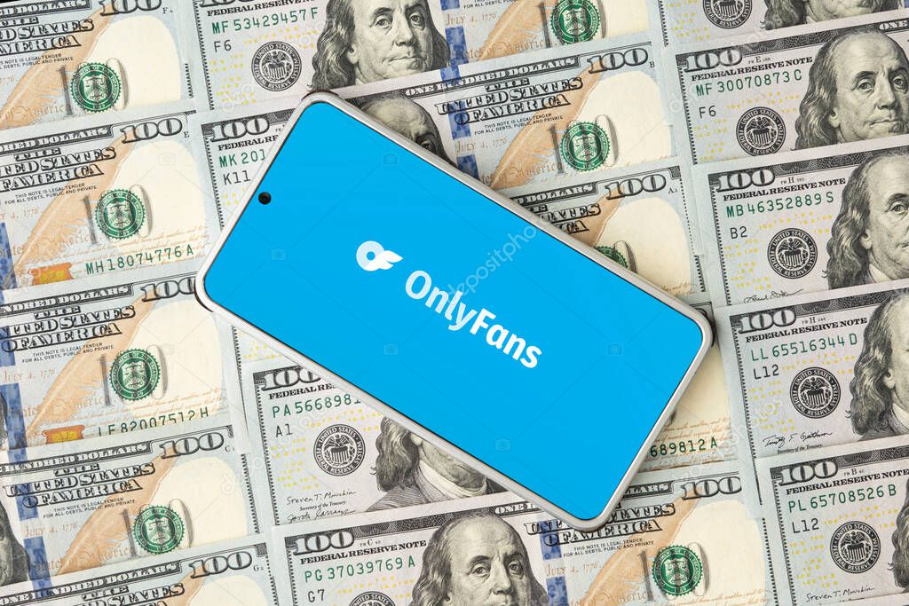 Onlyfans logo on smartphone screen and dollar bills. OnlyFans is content subscription service. March 30, 2023. Barnaul. Russia.