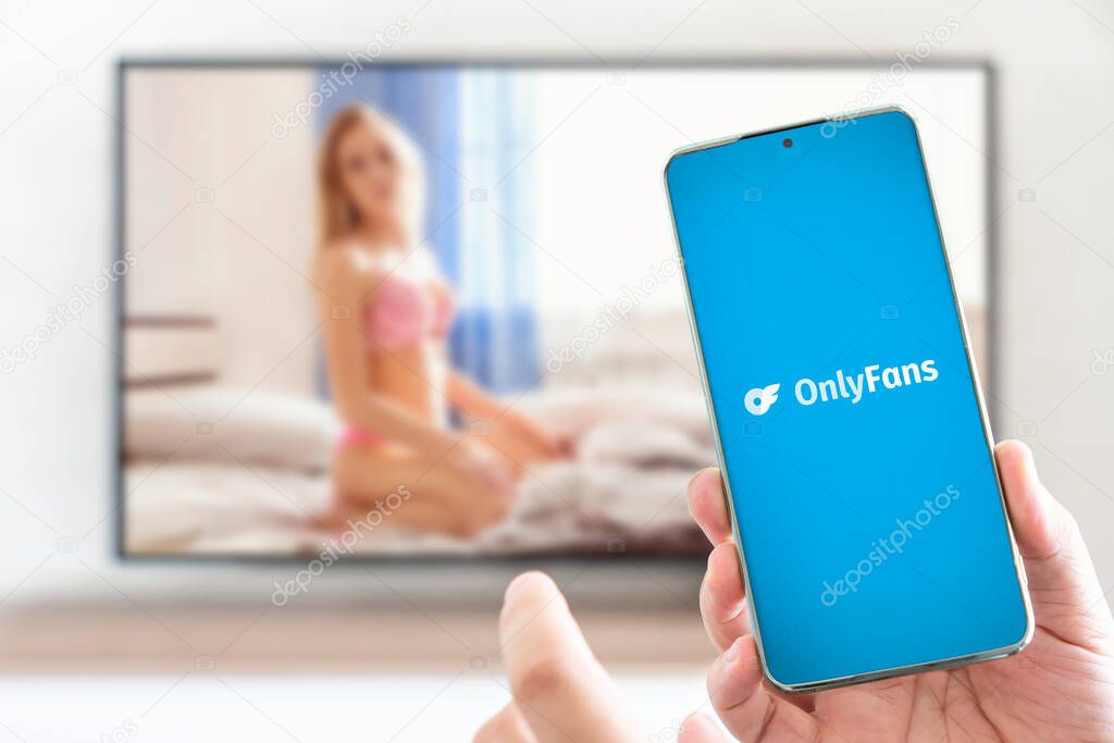 Barnaul. Russia March 28, 2023: OnlyFans logo on mobile phone in the hands of sexy women. OnlyFans is an internet paid content subscription service.