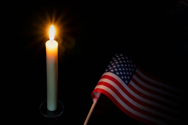 Mourning in the country united states of america. A burning candle on the background of the US flag. Victims of cataclysm or war concept. memorial day, remembrance day National mourning.