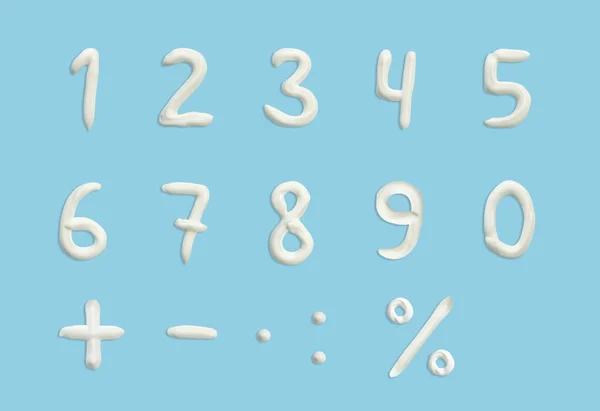 numbers of the English alphabet in the form of squeezed cream in white on a blue background.