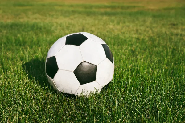 スタジアムの芝生の上に置かれた古典的なサッカーボール 典型的な黒と白のパターン アリーナの緑の芝生のフィールド上の伝統的なサッカーボール — ストック写真
