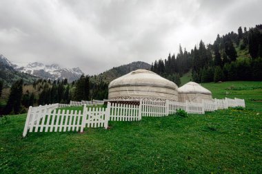 Sonbaharın başlarında, Almaty 'den çok da uzak olmayan dağların arka planındaki Kazak misafir yurdu. Almaty dağlarında geleneksel göçebe evi olan güzel bir manzara..