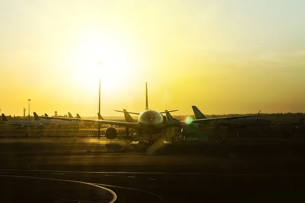 stock image Airplanes at sunset along the runway at international airport. arrival departure of the aircraft from the airfield, boarding the aircraft early in the morning at dawn