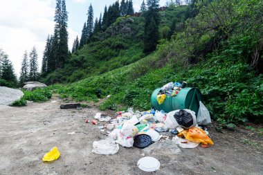 Parktaki ya da ormandaki bir ağacın altındaki plastik enkaz dağı. Ulusal parktaki doğa kirliliği, çöp öğütme sorunu.