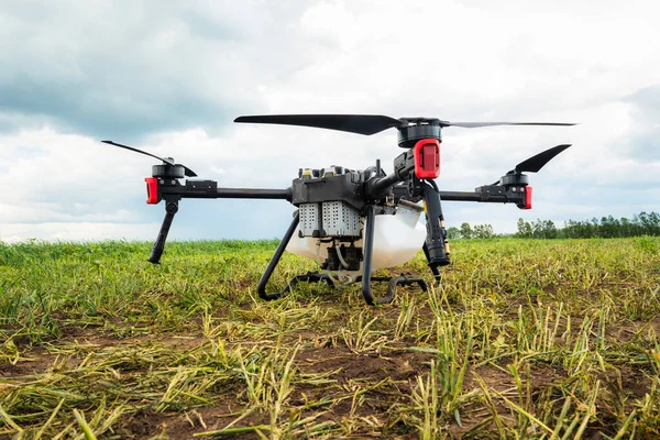 Agriculture drone against the background of blue sky and green fields with agricultural plants. drone for pollination of plants. Modern technologies in agriculture.