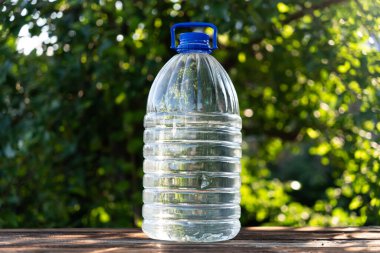 Plastik ve yeşil arka planda yapılmış şişe suyu. Görüntü yenileniyor ve alanı kopyalanıyor. 5 litre büyük plastik su kabı.