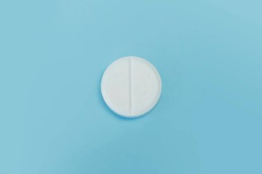 İlaç ve ilaç konsepti. Mavi arka planda beyaz hapın yakın plan görüntüsü. makro tablet