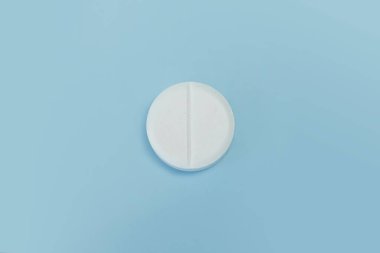 İlaç ve ilaç konsepti. Mavi arka planda beyaz hapın yakın plan görüntüsü. makro tablet