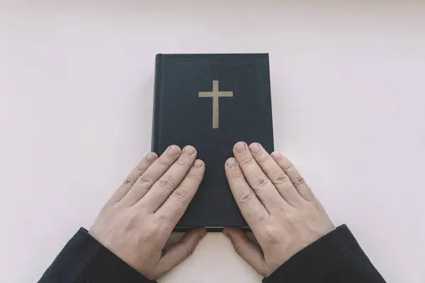 the Holy Bible in men\'s hands. The concept of faith and religion. christian faith. top view. priest is holding a book.