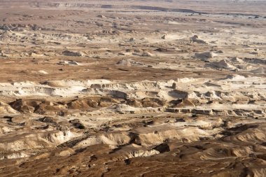 İsrail çölünün kumları manzaralı, uzaktan manzaralı bir yer. Kahverengi, bej ve terracotta renklerinde düz bir yüzey. Orta Doğu 'da bir çölün kurak ve cansız toprağı.