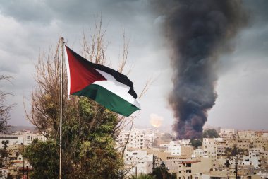 Dağdaki Filistin bayrağı şehirdeki evlerin arka planında. Orta Doğu 'daki savaş. Şehirde siyah dumanlı bir patlama.