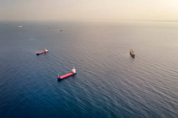 Many container ships at sea - Aerial image. Drone shot of boats sailing at misty horizon background. Concept of transportation and logistics. Ship with cargo near Haifa shore, Mediterranean sea