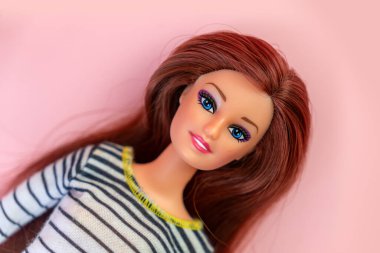 9 Ekim 2023. Barnaul, Rusya: Pembe arka planda esmer Barbie bebek portresi. Stüdyo çekimi.