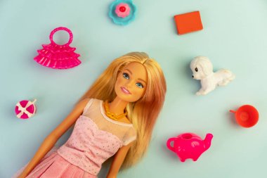 9 Ekim 2023. Barnaul, Rusya: Mavi arka planda oturan gevşek sarı saçlı Barbie bebek.