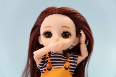 Mavi arka planda korkmuş bir plastik bebek. Çocukların korku ve dehşeti kavramı. şaşkın gözler