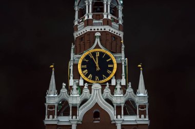 Moskova Kremlin 'in Spasskaya Kulesi' nin çan seslerinde kara bulutlu bir gökyüzünün arka planına karşı 12 saat. Yeni yıla 5 dakika kaldı..