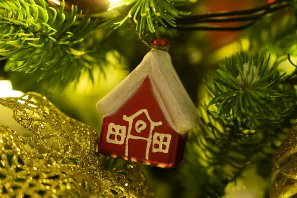 Christmas tree decoration in the form of a house on a branch. housing rental concept, realtor services, mortgage, purchase, loan