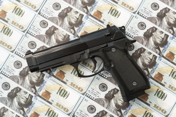 black gun on the background of cash dollars. the concept of criminal money or murder for money. bank robbery,