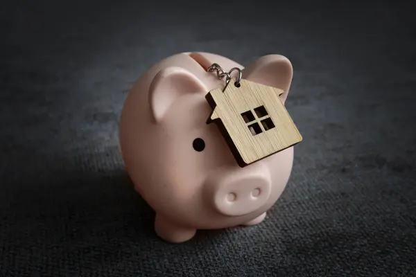 The concept of saving up for your real estate. Save on rent. the keychain is in the piggy bank at home.
