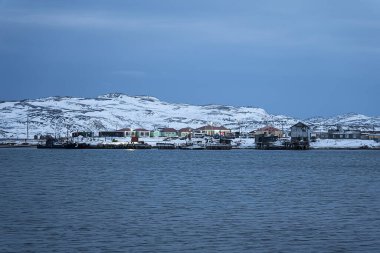 old fishing village on the shore of the sea. Teriberka is a village on the shore of the Arctic Ocean. The edge of the world. The far north of Russia. clipart