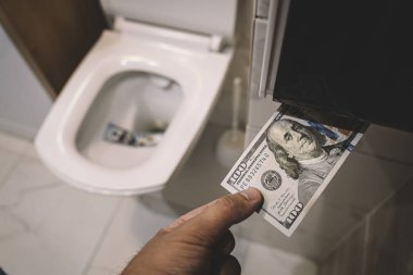 Sifonu çek, banknotları tuvalete at, kayıp konsepti kapat, seçici odaklan. Anlamsız para israfı, kayıp, işe yaramaz atıklar, büyük su maliyetleri kavramı,