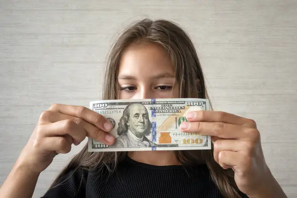 Money, finances and people concept - smiling little girl with dollar cash money. children\'s money