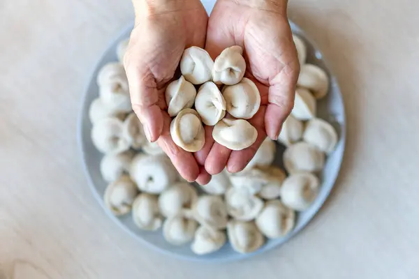 hands make dumplings, hands kneading dough, baker, Baker\'s hands, dough, hands in the flour, dumplings, handmade dumplings, ravioli view from above ,