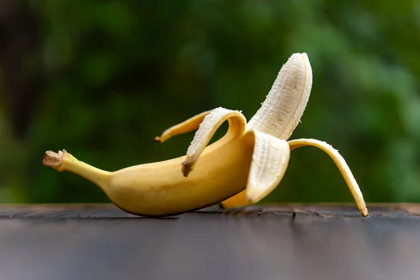 新鲜水果的成分 整个新鲜美味的香蕉 没有皮肤 在模糊的自然背景下 图库照片
